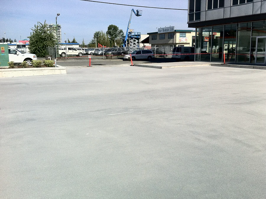 The exterior parkade deck of a strata building in Abbotsford with the aggregate broadcast across it, up to the storefront walkway