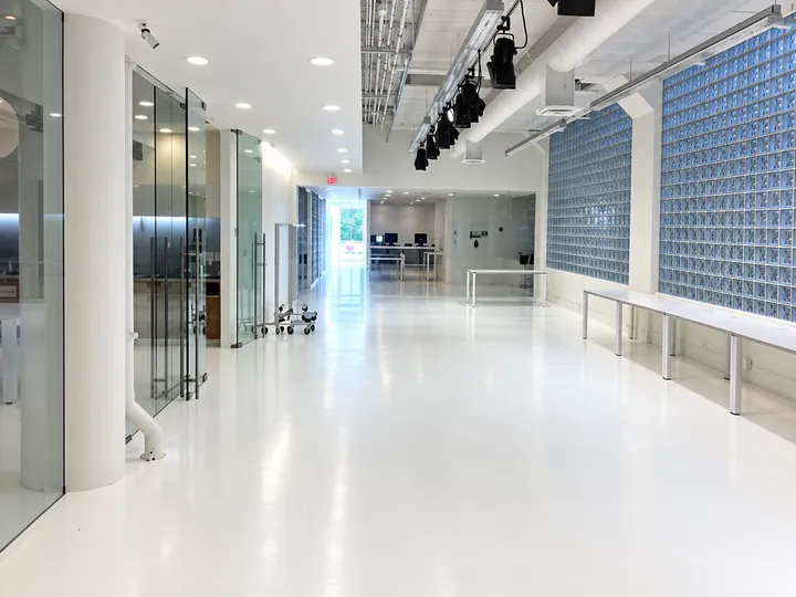Seamless white resin floor running through a glazed office corridor at the Aritzia head office