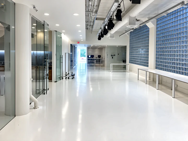 Seamless white resin floor through a glazed office corridor at the Aritzia head office