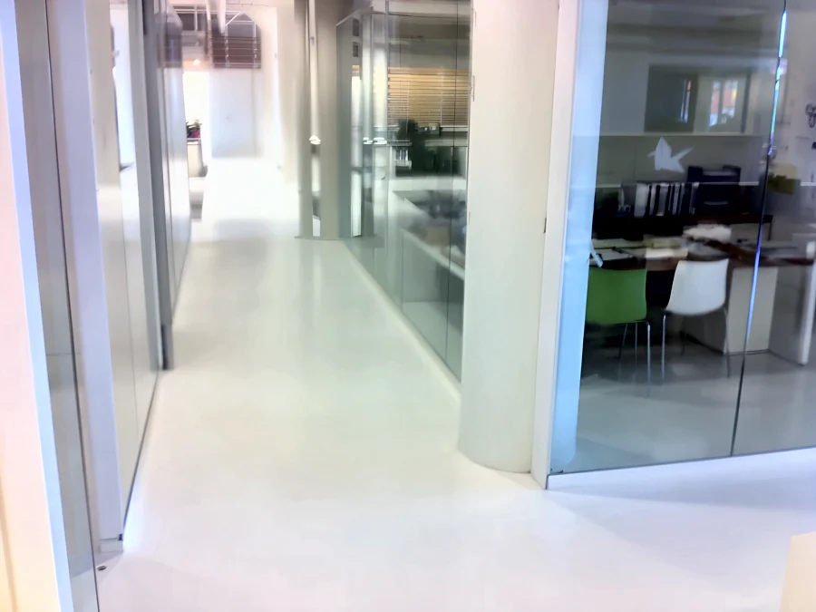 White urethane floor along a corridor past glass-fronted offices at the Aritzia head office