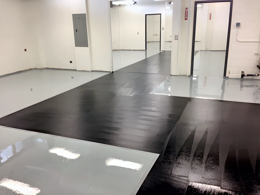 The corridor of a BC Hydro facility in a black coat between rooms already finished in the grey ESD floor