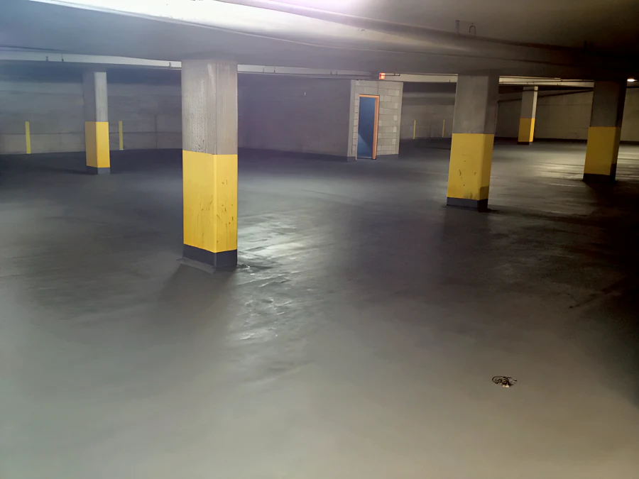 Kelmar FWC III traffic coating across a parking level of the Beach Avenue apartments parkade in Vancouver, around the yellow-banded columns