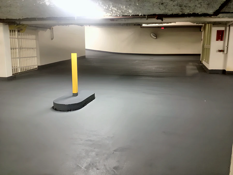 Kelmar FWC III traffic coating by the ramp in the Beach Avenue apartments parkade, Vancouver, carried over the curb of a bollard and up the wall bases