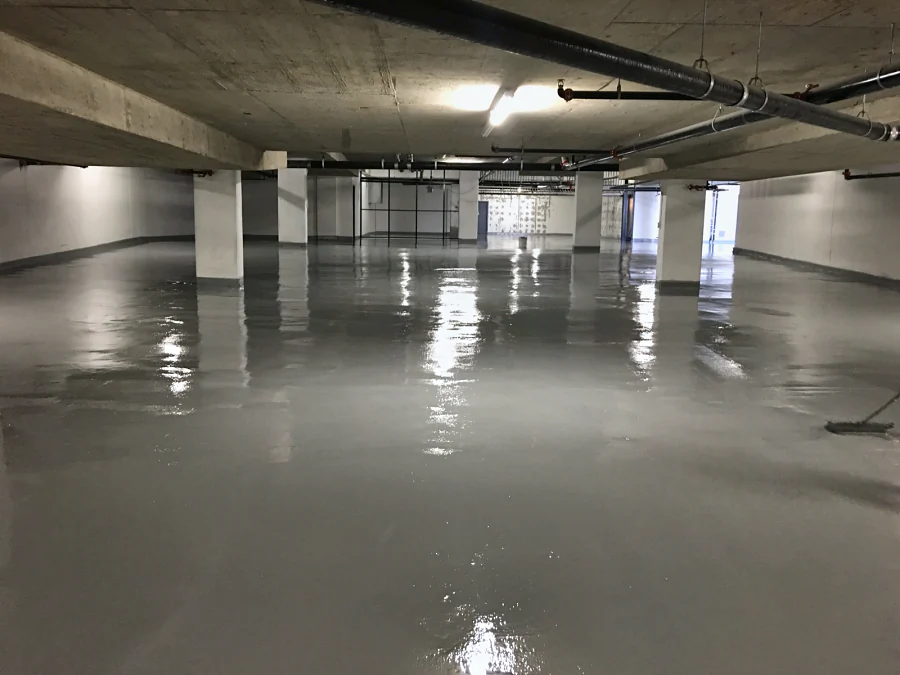 A fresh Tremco Vulkem coat, still wet, across a whole parking level of a Brentwood parkade in Burnaby