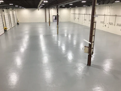 A Burnaby warehouse floor finished in epoxy and urethane, glossy light grey past the overhead doors
