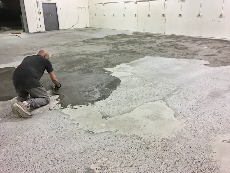 A concrete repair trowelled out by hand across a warehouse slab in Burnaby, 2016
