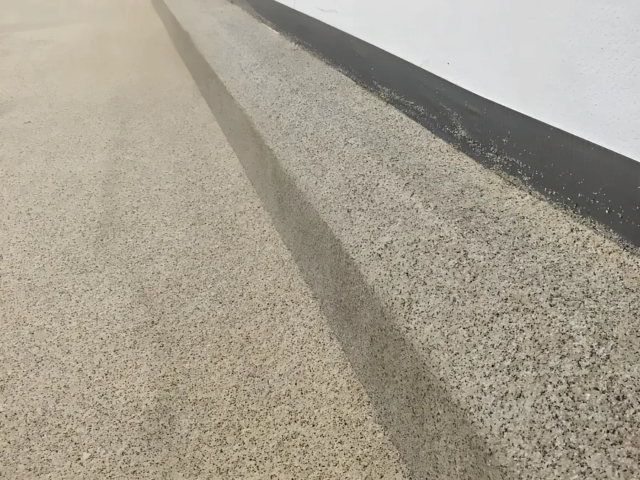 Decorative quartz turned up the wall as a raised coved curb along an insulated-panel room at Costco Kamloops