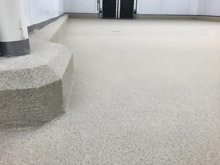 Decorative quartz floor at Costco Kamloops carried up and over an octagonal plinth round a pipe and along a raised coved curb