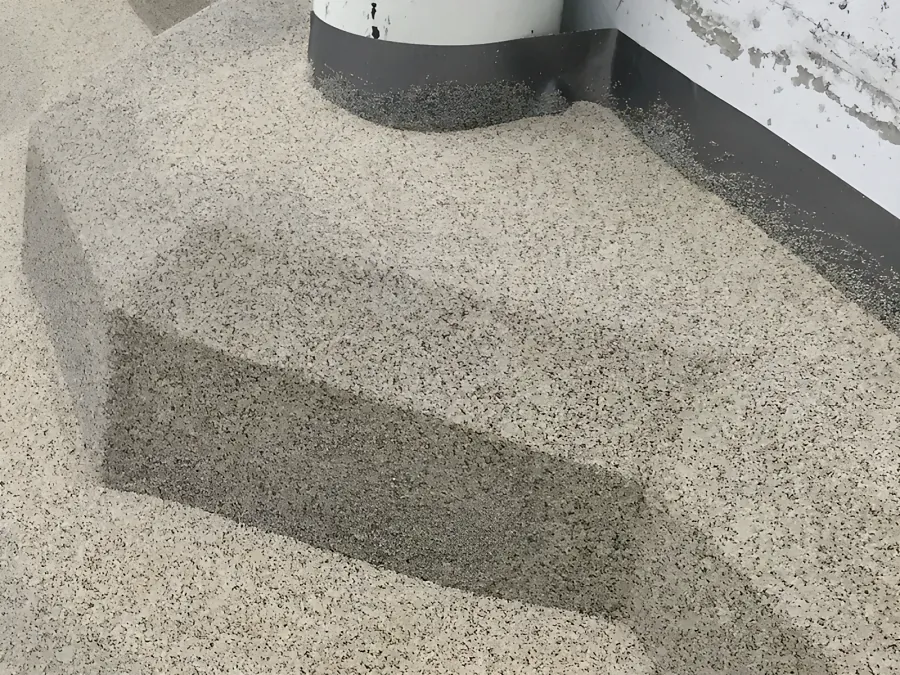 Decorative quartz carried round the corner of a plinth and up under a pipe at Costco Kamloops