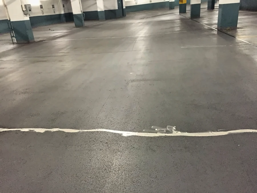 The filled crack running across the concrete drive aisle of a Downtown Vancouver parkade, ready for the traffic coating