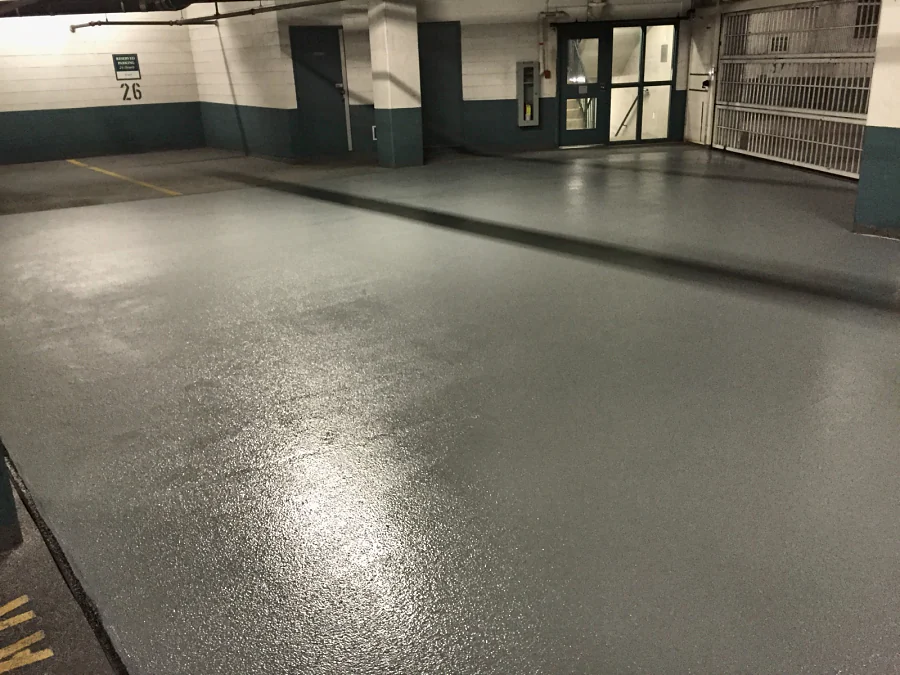 Finished grey traffic coating with a textured surface in front of the lobby doors and parking gate of a Downtown Vancouver parkade