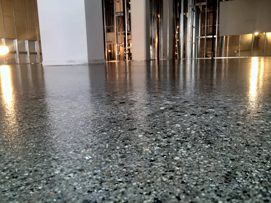 Close-up of the clear coat over the concrete at a Downtown Vancouver restaurant, the stone in the slab visible under the gloss