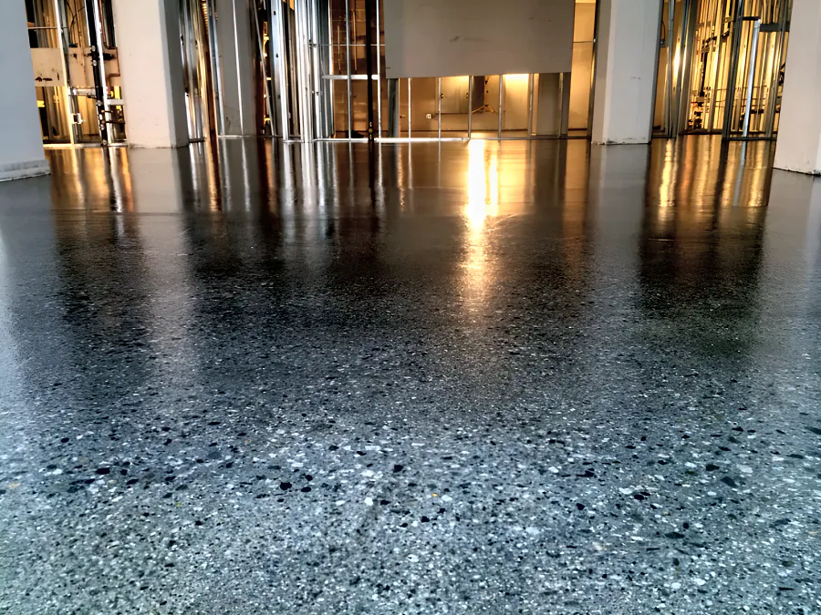 High-gloss clear epoxy and urethane coating over the concrete of a Downtown Vancouver restaurant during the fit-out, the slab aggregate showing through
