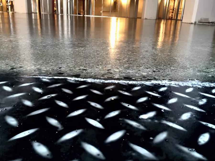 Clear-coated concrete meeting a black diamond-pattern floor at a Downtown Vancouver restaurant