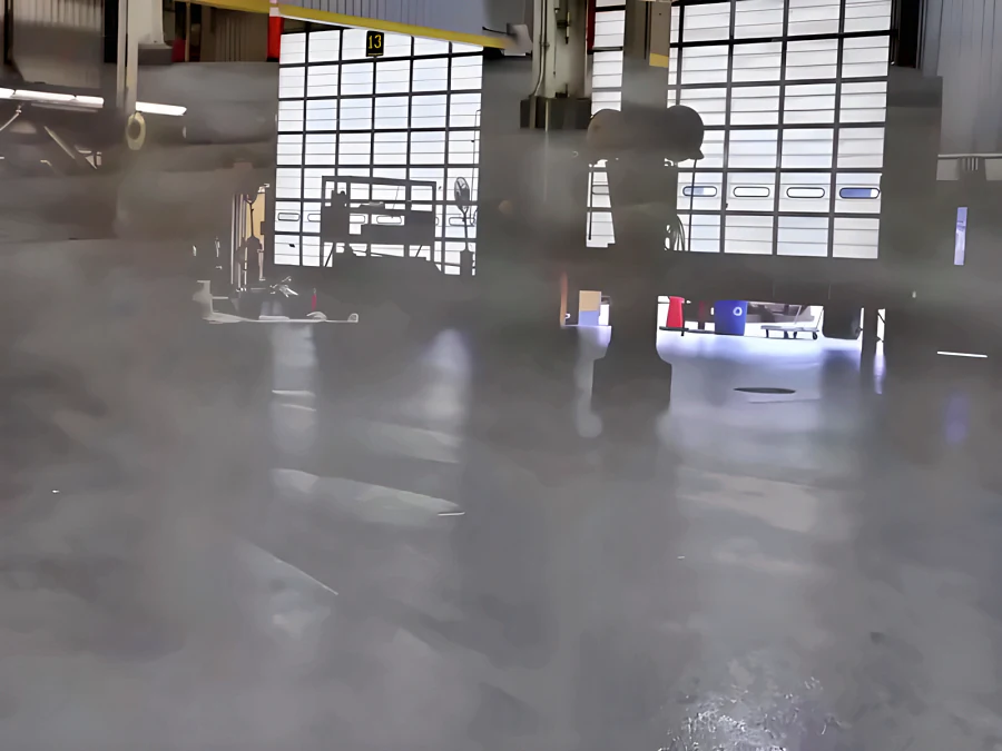 Finished grey ResinTech EWS floor in a Finning heavy-equipment workshop, with open roller doors