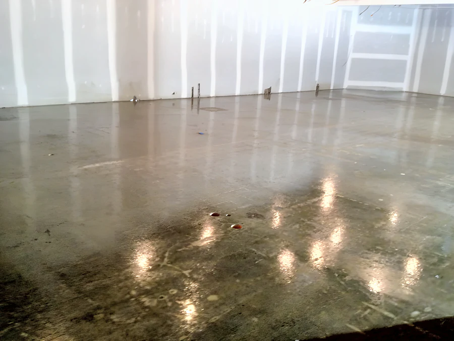Polished concrete across the Fresh St. Market floor in West Vancouver before the fit-out, reflecting the work lights
