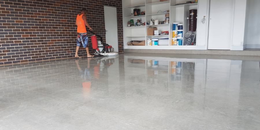 Operator running a floor grinder inside an occupied retail space