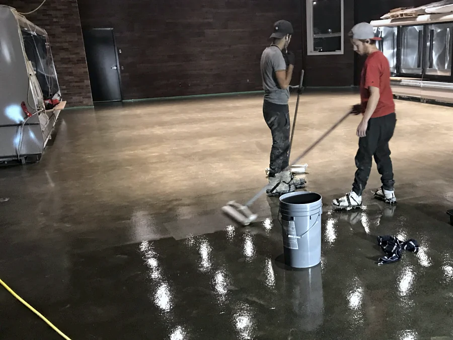 The crew rolling out the clear coat across the concrete floor of a farm market in Langley