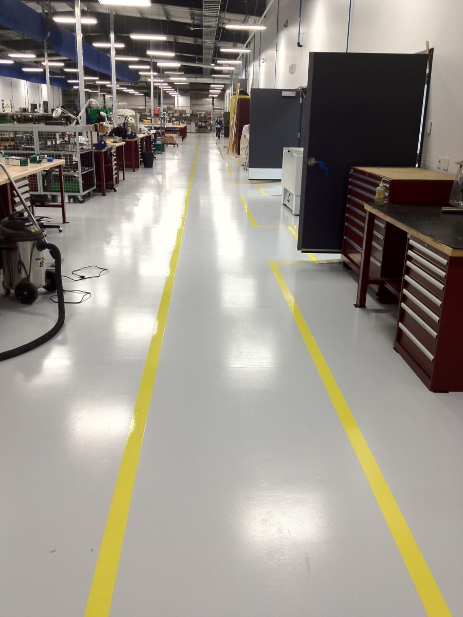 Industrial aisle with yellow traffic lines on a light epoxy floor