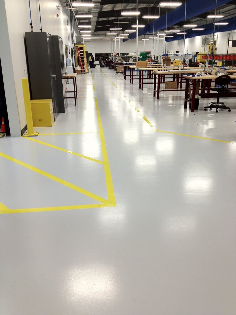 Workshop floor in light epoxy with yellow bay line marking