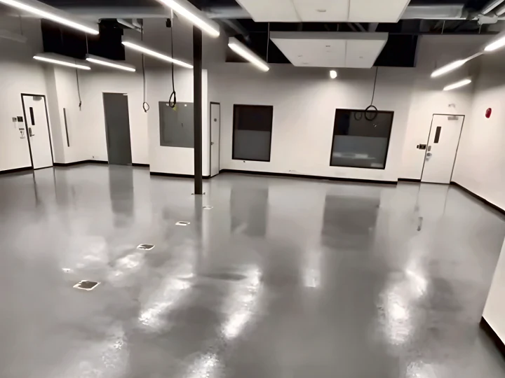 Glossy grey ResinTech TUE floor across the Lush manufacturing floor, under rows of linear lights