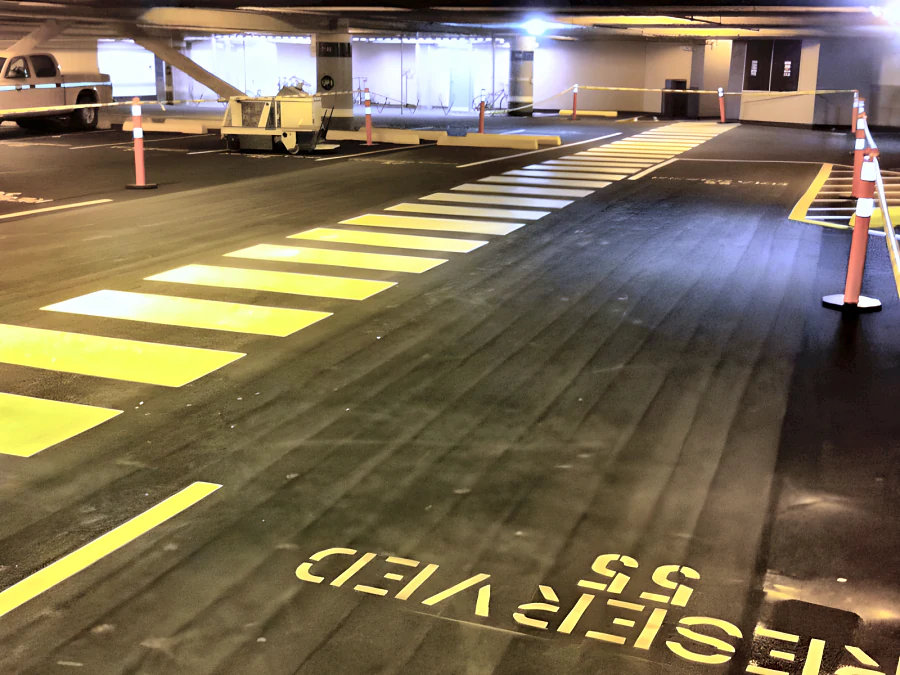 Kelmar T.E. parkade coating at Metrotown with new yellow crosswalk, stall lines and a reserved-stall marking
