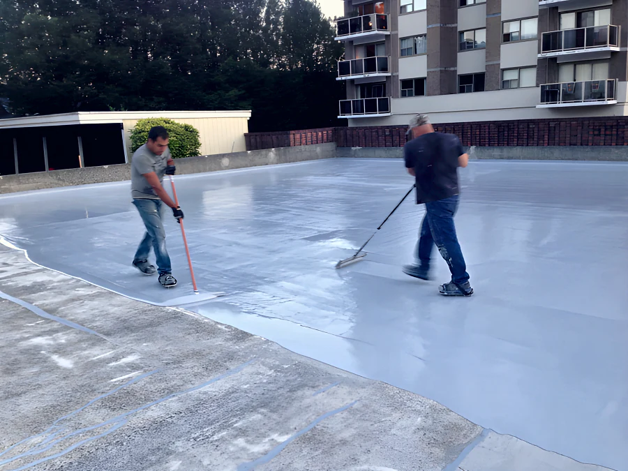 Crew squeegeeing the MasterSeal Traffic 1500 (formerly Sonoguard) membrane out across the concrete of an exterior parkade deck in New Westminster