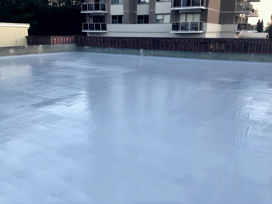 Finished grey MasterSeal Traffic 1500 traffic membrane with its UV-stable top coat across an exterior parkade deck in New Westminster, inside the brick parapet