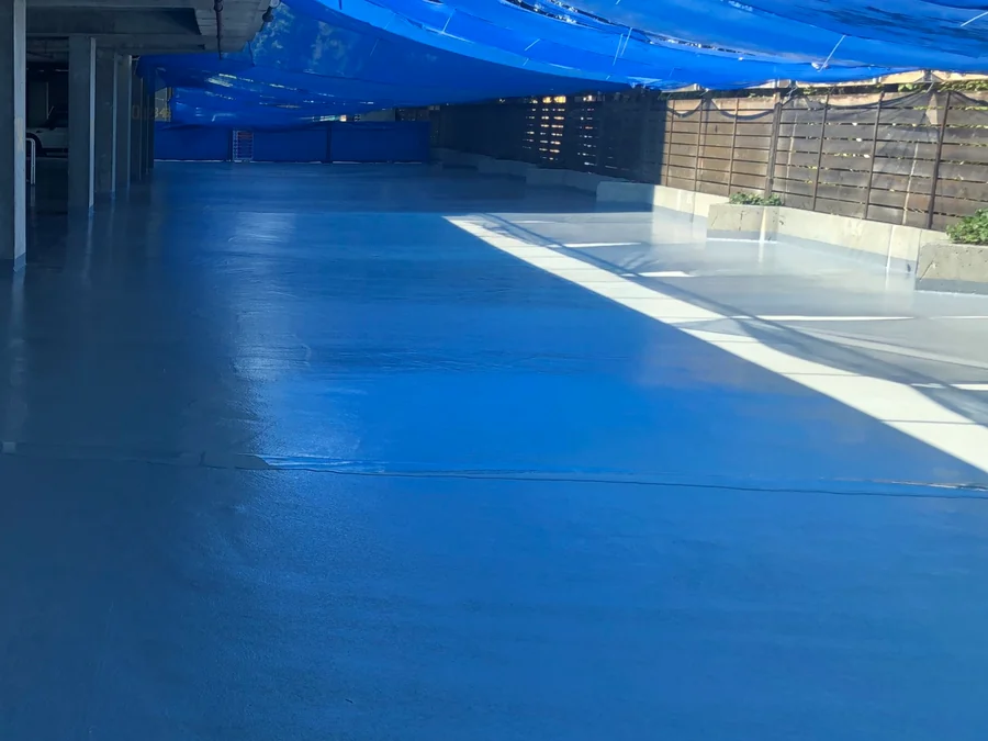 The traffic coating across the parkade deck to the fence under the tarps, New Westminster residential tower
