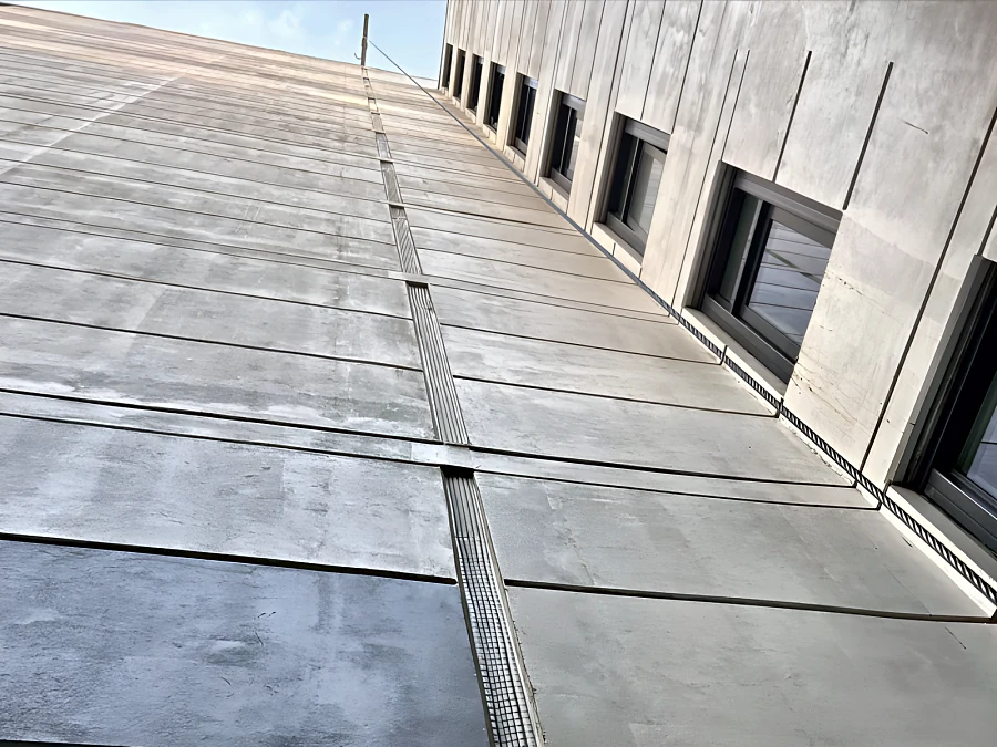 Expansion joint cover along the face of an Onni building, seen from below