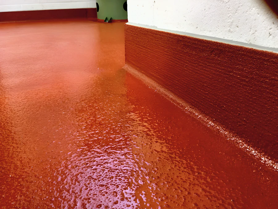 Close-up of the red Eco Shop Floor turned up the block wall as a textured cove base at Parallel 49 Brewing Company