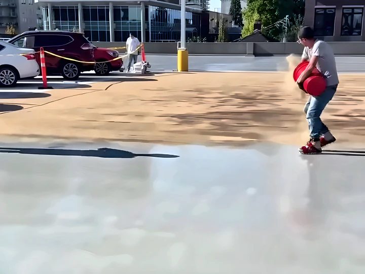 Crew broadcasting sand into the new ResinTech EWS system on the exposed parkade deck after the old membrane was removed