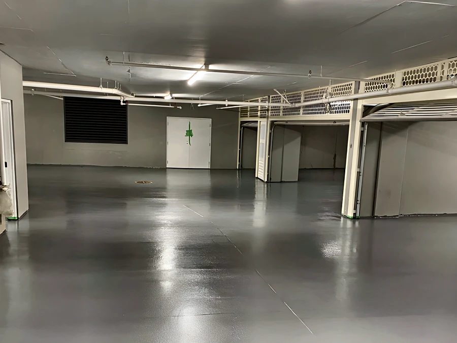 Grey traffic coating across a parking level beneath a residential tower