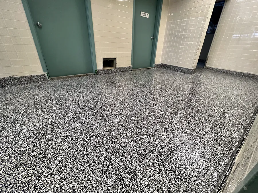 The ResinTech EWS flake floor across the room to the doorway, the coved flake base running round the tiled walls