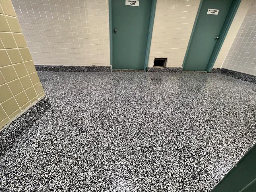 The ResinTech EWS flake floor by the furnace and electrical room doors, carried up the walls and round the corner as a coved base