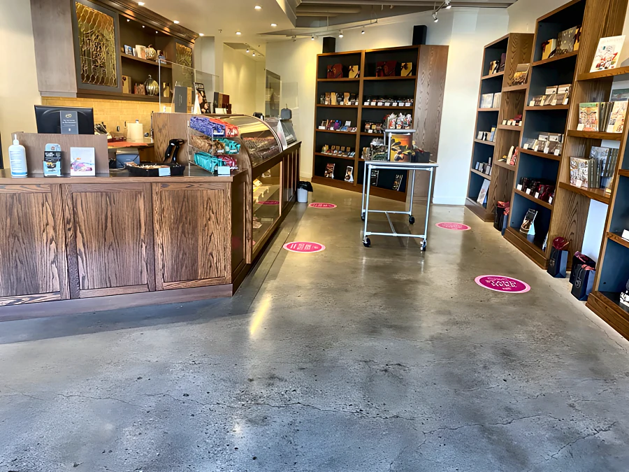 Polished concrete sales floor in a Rogers’ Chocolates shop, between the counter and the shelving