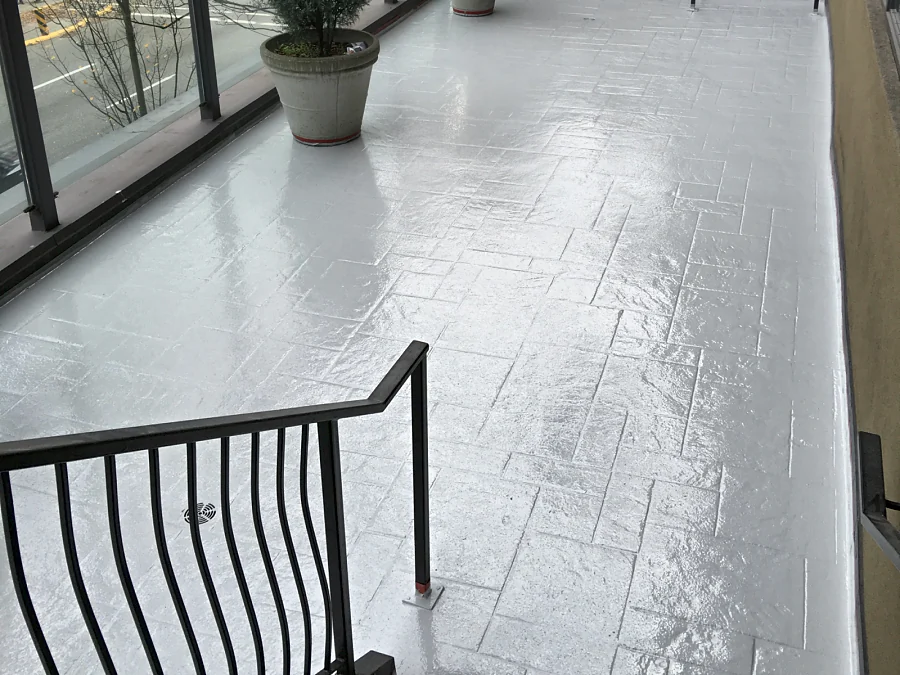 The Moxies patio at the Sandman Hotel West Georgia seen from the stairs, finished in a glossy grey traffic coating over the patterned deck