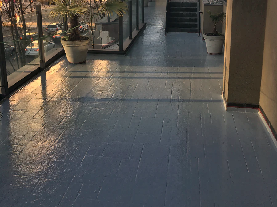 The grey traffic coating carried along the Moxies patio to the stairs at the Sandman Hotel West Georgia, the planters left in place