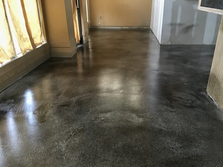 The stained and polished floor running along the windows of a commercial fit-out, the glazing still papered over
