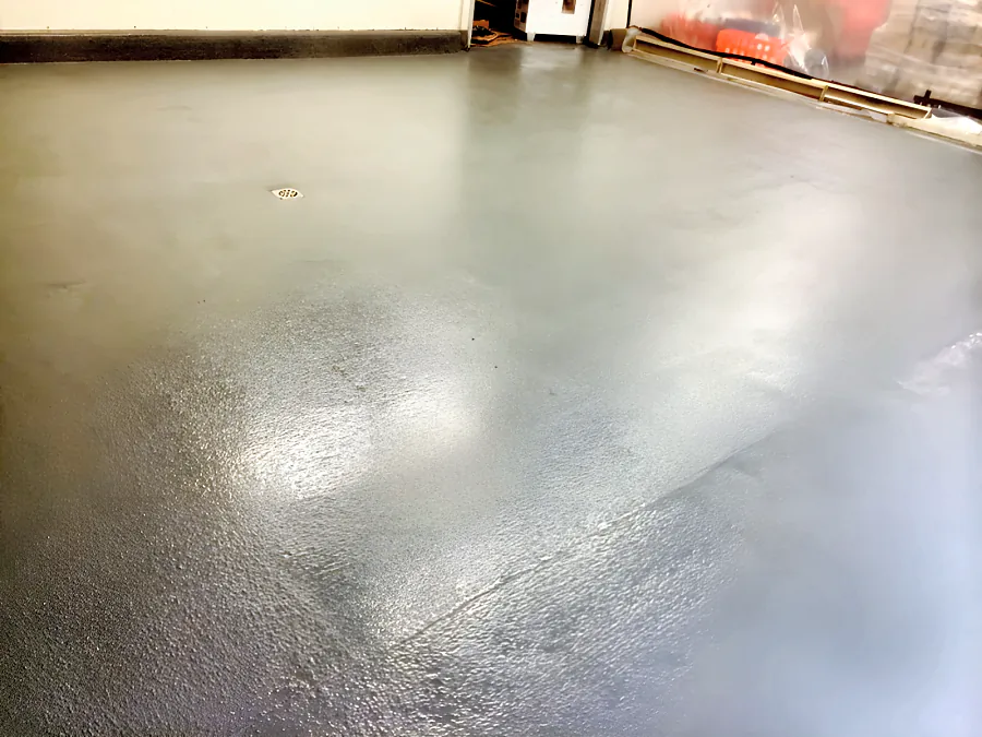 Finished grey epoxy floor in the milk walk-in cooler at the Real Canadian Superstore in Surrey, textured, round the drain and coved at the wall