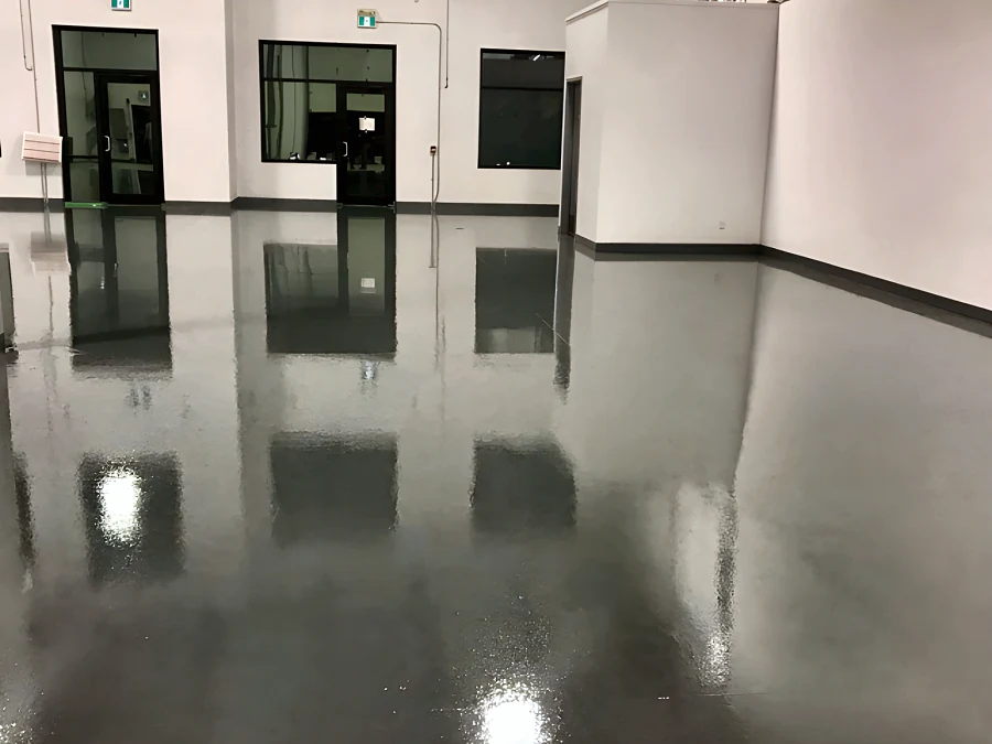 Reflective 100% solids epoxy floor in a Surrey warehouse, looking towards the glazed entrance