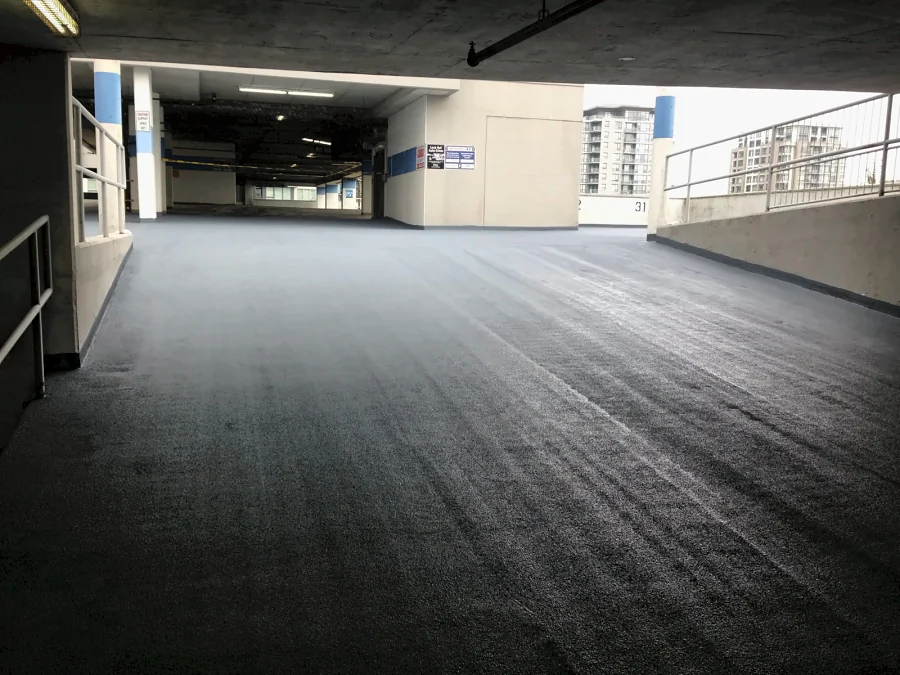 The ramp at level P5A of the Three West Centre parkade in Richmond finished in a dark grey textured traffic coating