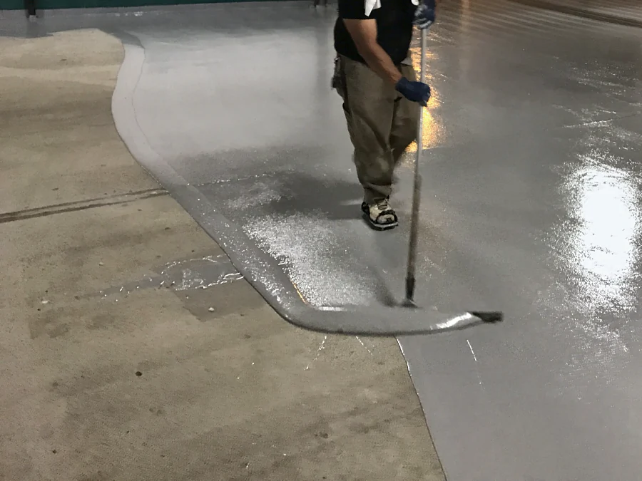 The grey coat pushed out by squeegee over the bare concrete slab in the Vancity parkade in Vancouver