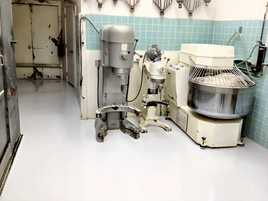 Light grey resinous floor in the mixing room of a Vancouver bakery, laid right up to the bases of the planetary and spiral dough mixers
