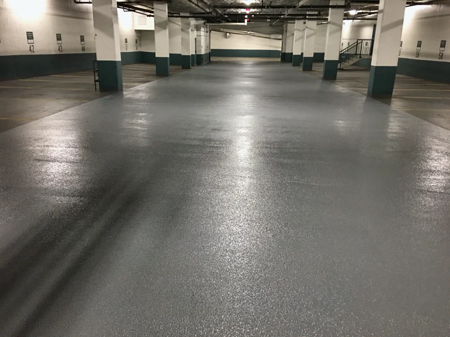 The same drive aisle of a Vancouver residential parkade recoated in a grey textured top coat over the existing membrane, 2016
