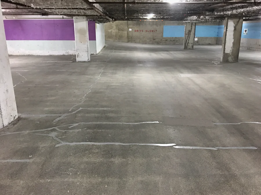 The slab of a residential parkade on West Broadway, Vancouver, with its cracks treated before the Mapei traffic coating