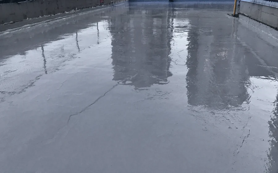 The Tremco Vulkem 360NF/346 coat over the same repaired exterior deck, the repaired cracks still showing through the wet film