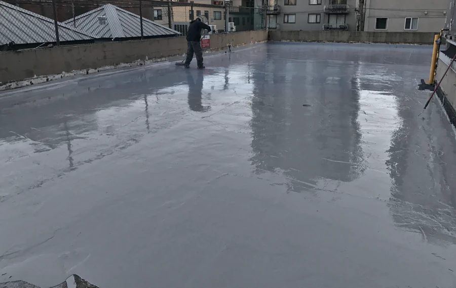 The Tremco Vulkem 360NF/346 coat being squeegeed across the exterior deck, still wet