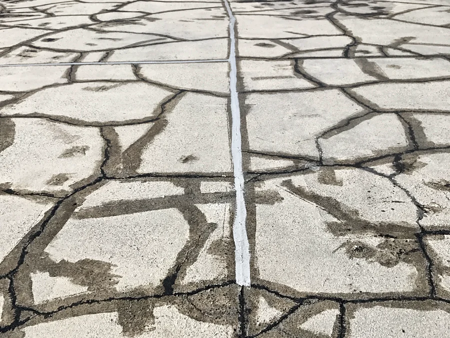 A cracked exterior parkade deck in Vancouver’s West End with its cracks repaired before a Tremco Vulkem traffic membrane