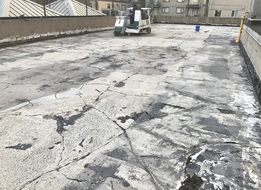 A ride-on shot blaster preparing an exterior parkade deck in Vancouver’s West End after the old membrane was removed